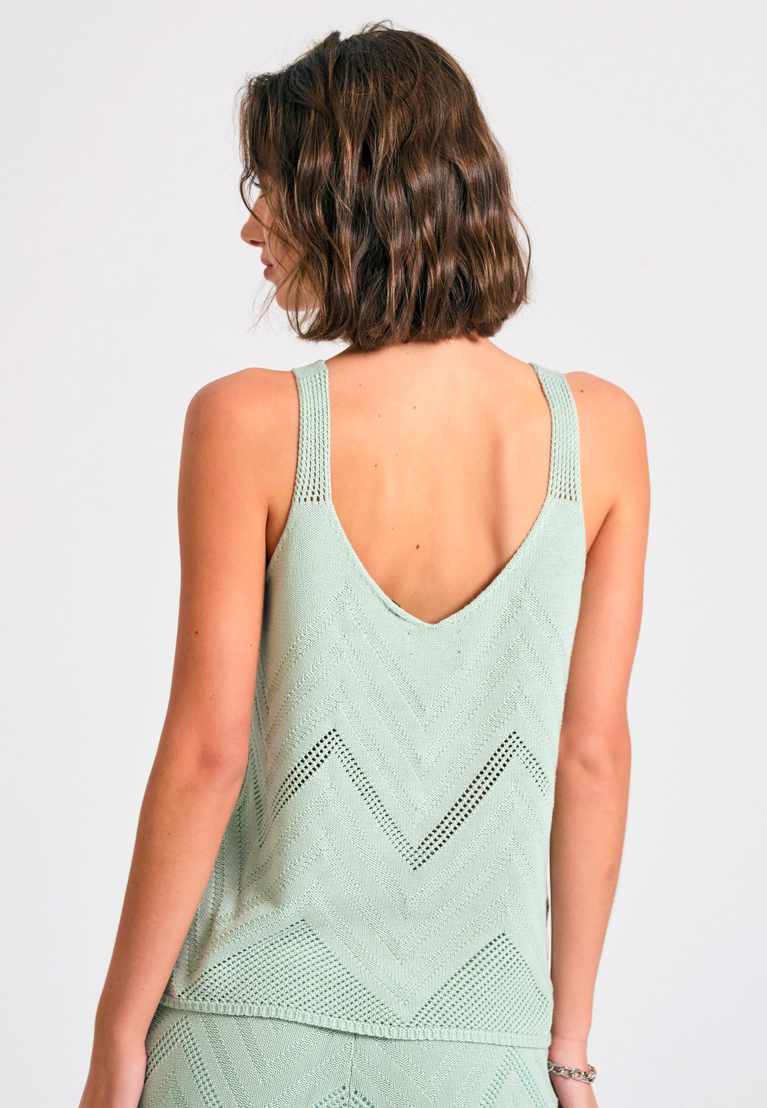 Γυναικεία πλεκτή αμάνικη μπλούζα σε ζακάρ ύφανση φωτογραφία